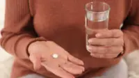 Woman holding table with a glass of water