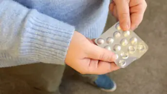 A woman holding antipsychotic tablets