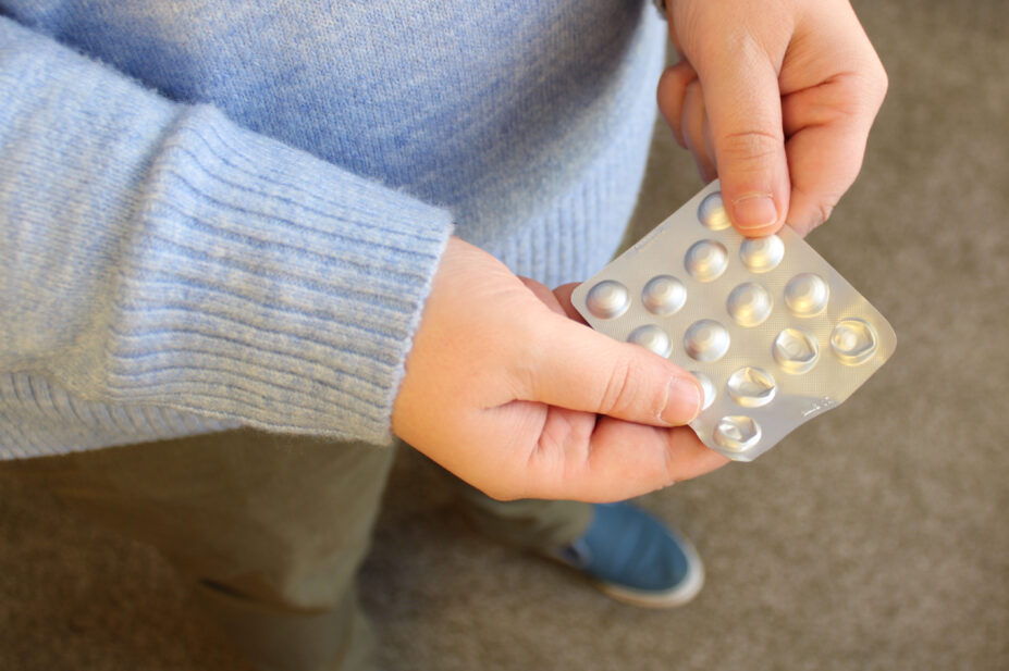 A woman holding antipsychotic tablets