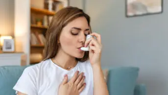 Woman uses asthma inhaler