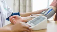 Pharmacist conducts blood pressure check on patient