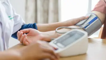 Pharmacist conducts blood pressure check on patient