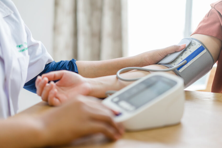 Pharmacist conducts blood pressure check on patient