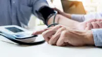 Pharmacist conducts blood pressure check on patient