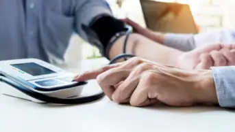 Pharmacist conducts blood pressure check on patient