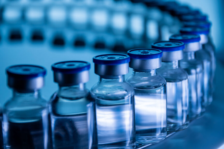 A group of vaccine bottles on a conveyor belt