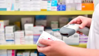 Pharmacist scanning medicine box in pharmacy