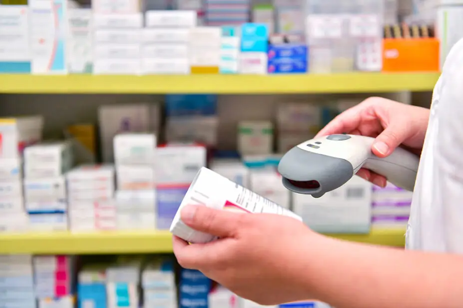 Pharmacist scanning medicine box in pharmacy