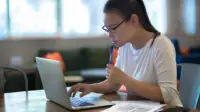 A woman using laptop at home to job hunt