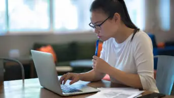 A woman using laptop at home to job hunt