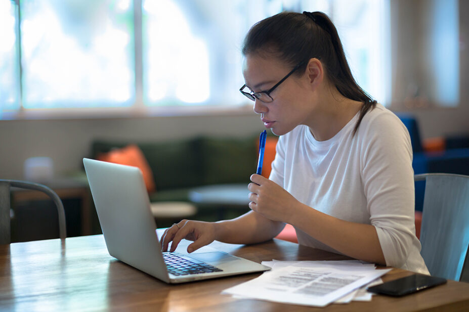 A woman using laptop at home to job hunt