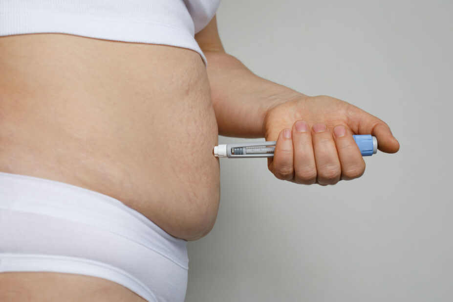 Woman using semaglutide injection pen in her stomach