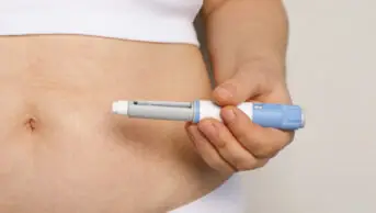 Woman holds weight-loss injection pen