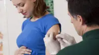 Pregnant woman getting vaccination jab