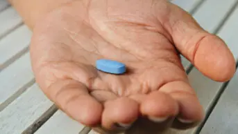 A man holds a blue pill