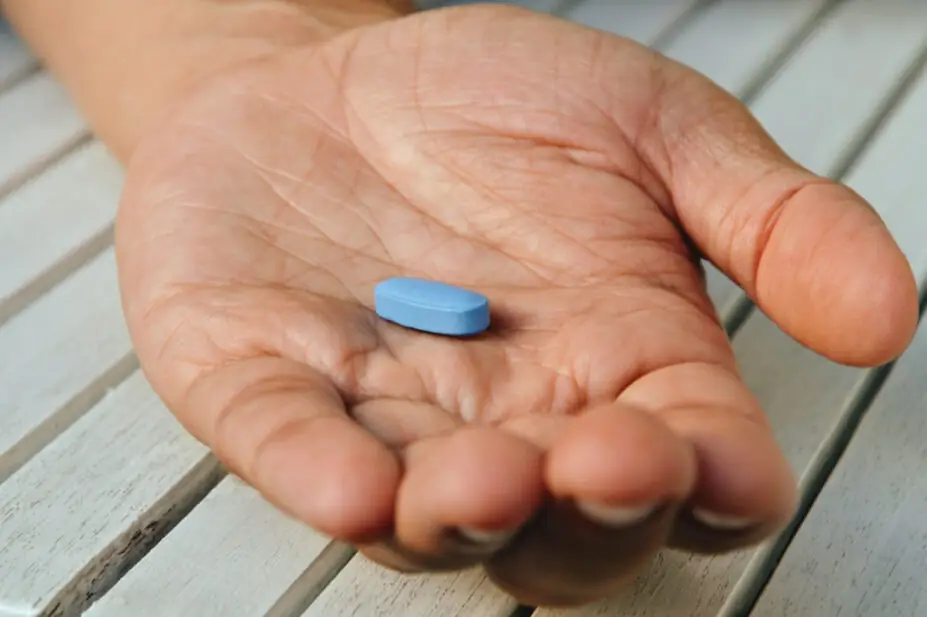 A man holds a blue pill