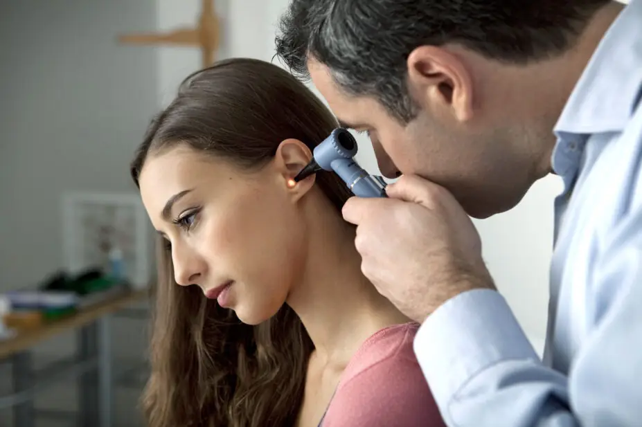 Woman has ear checked by healthcare professional