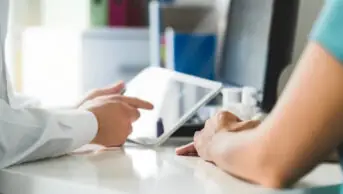 Pharmacist prescribes medicines to a patient on a tablet