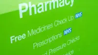 NHS prescriptions sign in pharmacy shop window