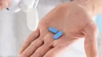 Man pours PrEP tablets into his hand