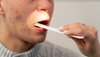 A healthcare professional examines a patient's throat