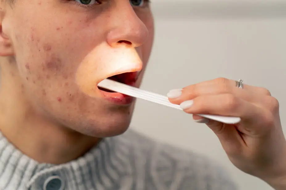 A healthcare professional examines a patient's throat