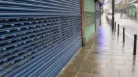 A high street shop with its shutters closed