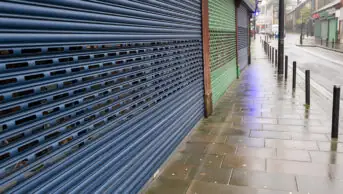 A high street shop with its shutters closed