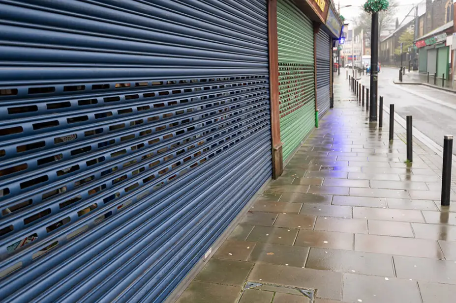 A high street shop with its shutters closed