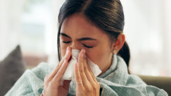 A woman blows her nose