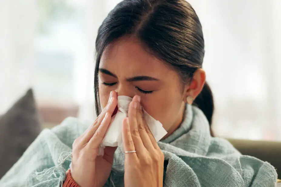 A woman blows her nose