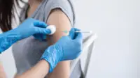 Healthcare professional injects flu vaccine into patient's arm