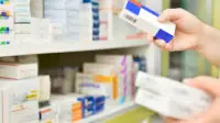 Pharmacist holding boxes of medicines