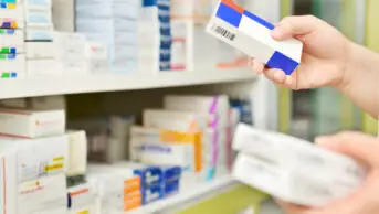 Pharmacist holding boxes of medicines