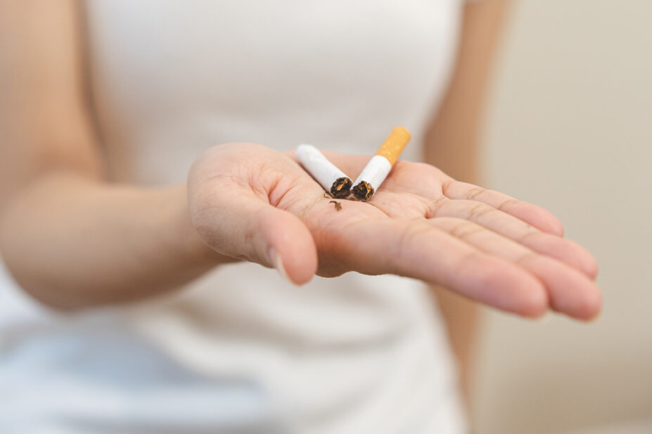 Young woman holding a broken cigarette in her hand