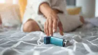 Woman reaches for her asthma inhaler