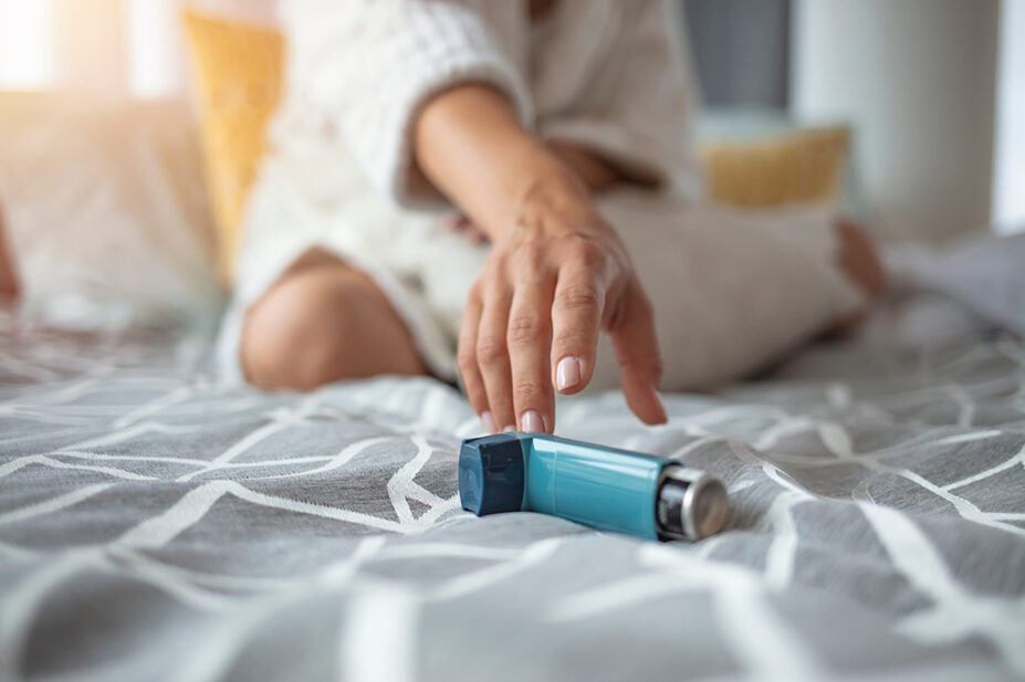 Woman reaches for her asthma inhaler