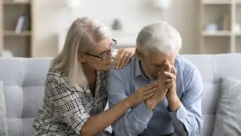 Photo of loving empathetic mature wife consoling depressed elder husband