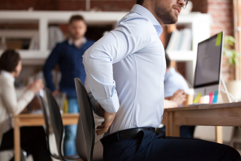 Man sitting at a desk experiences back pain