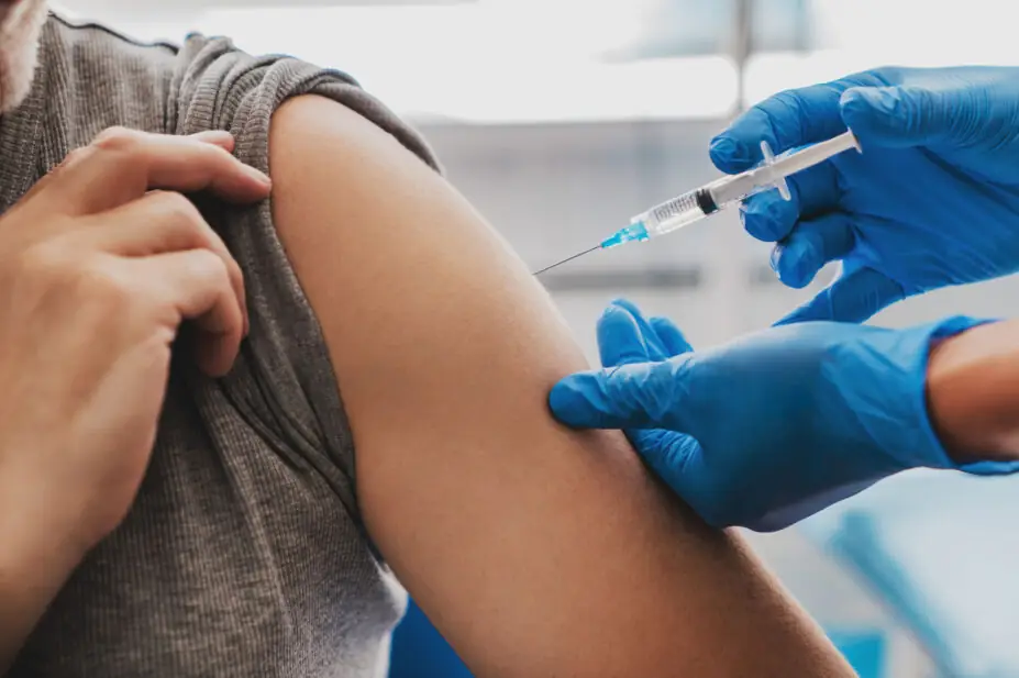 A man receives an injection from a healthcare professional