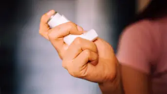 A woman holders an asthma inhaler