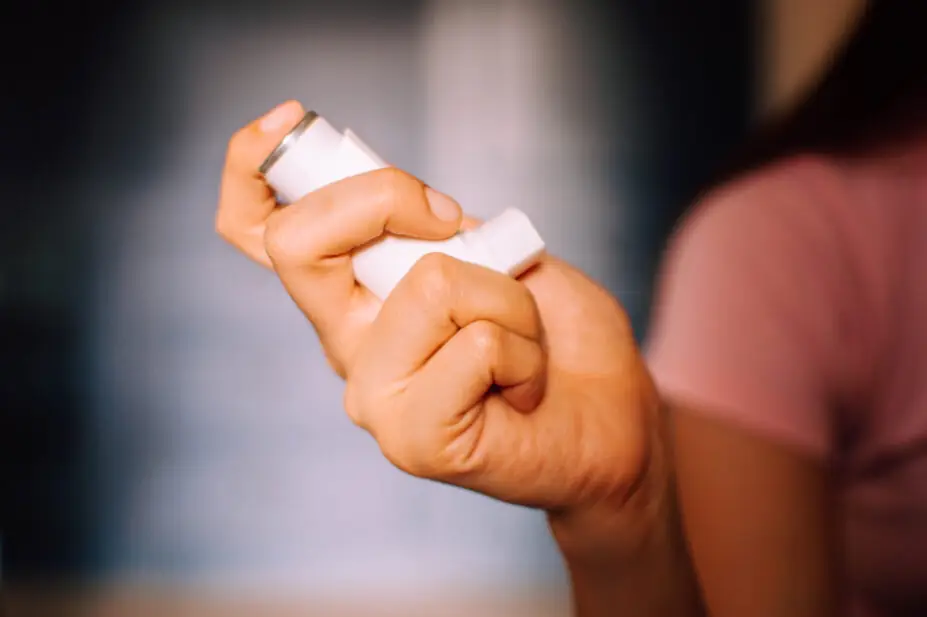 A woman holders an asthma inhaler