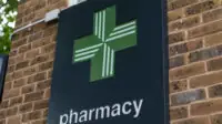 Pharmacy cross signage outside a Boots pharmacy