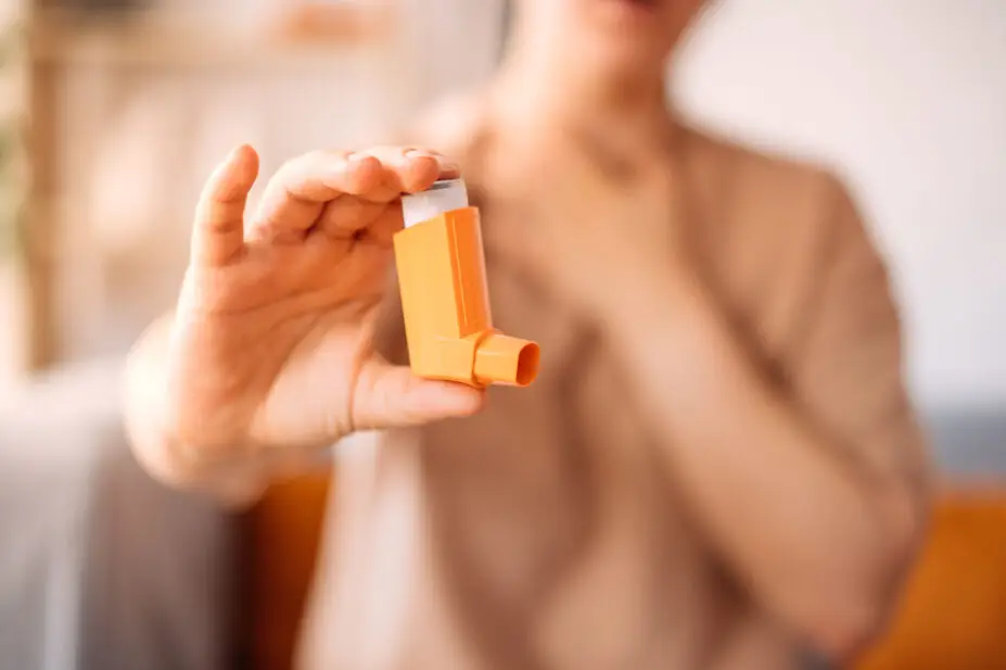 A woman suffering from asthma holds an inhaler