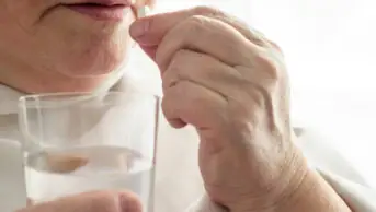 A woman takes a direct oral anticoagulant pill