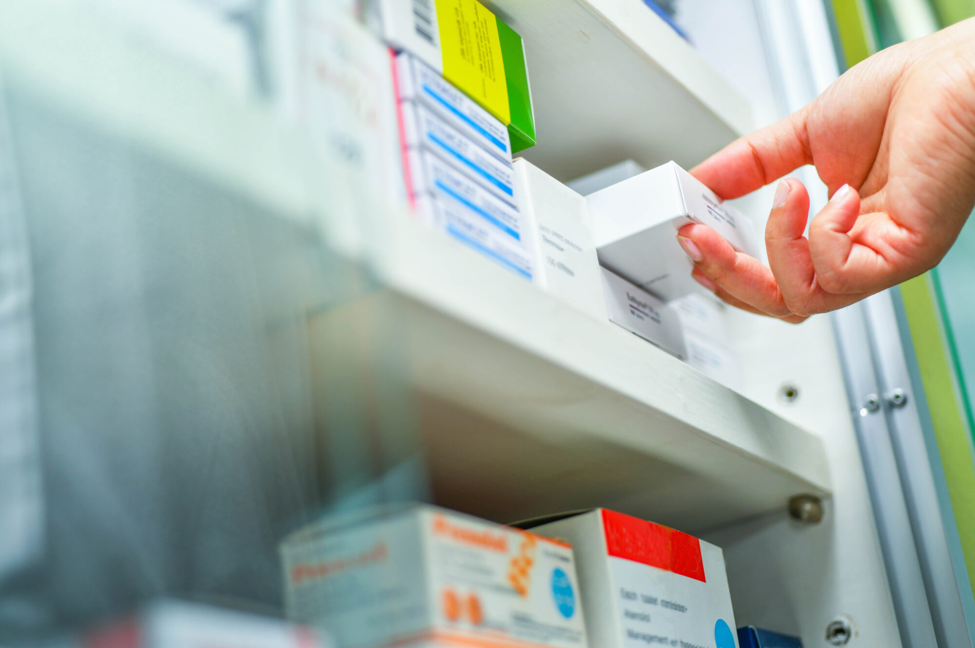 A pharmacist holds a box of medicine