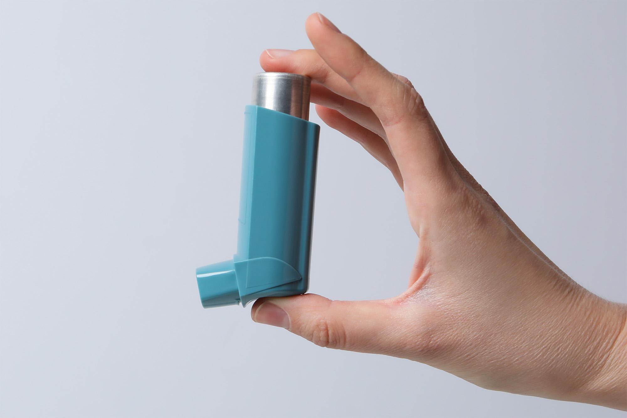 Photo of a hand holding an inhaler