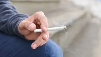 Man holding cigarette in his hand, close up