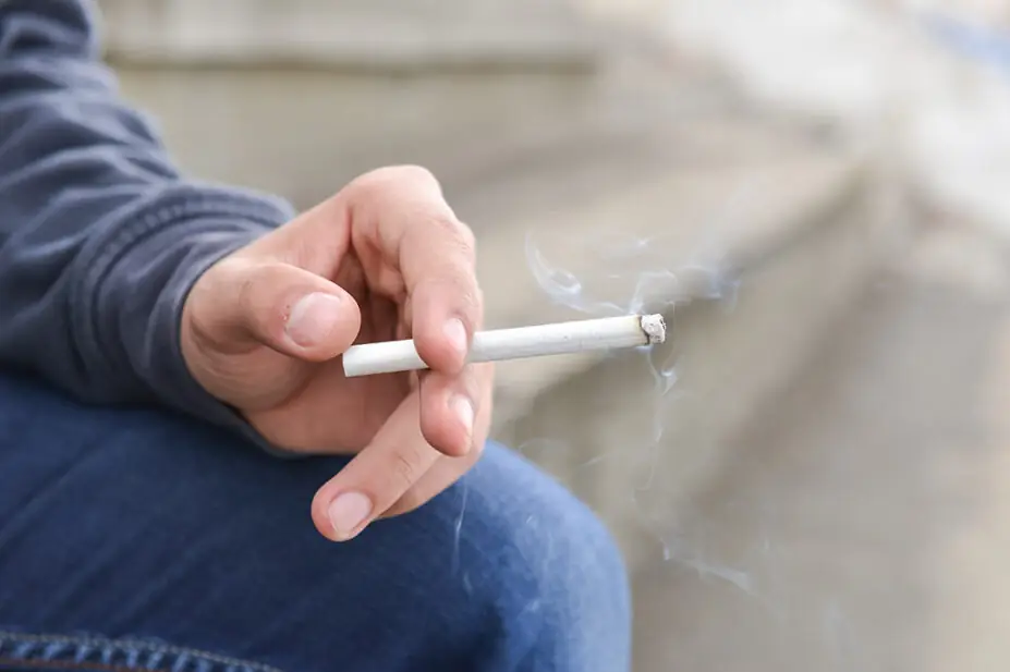 Man holding cigarette in his hand, close up