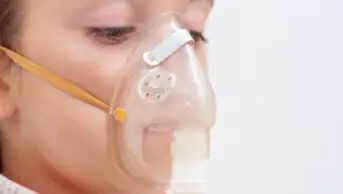 A woman breathes through a nebuliser